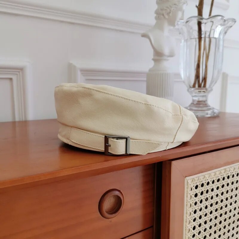 Leather Beret With Faux Leather and Buckle on a wooden desk